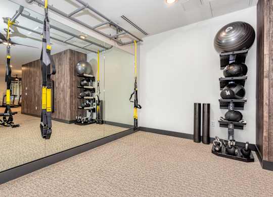 Resident gym with weight and mirrored walls at Sylvan Uptown, Denver