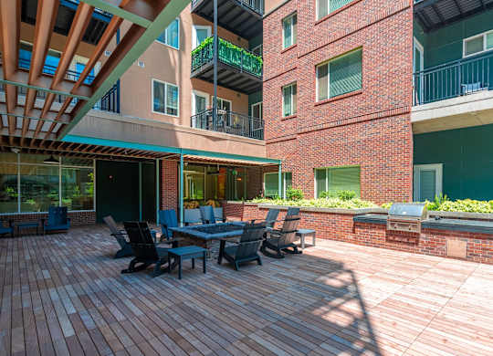 View of the resident fire pit lounge and patio area with bbq grills and red brick walls at Sylvan Uptown,Colorado, Denver