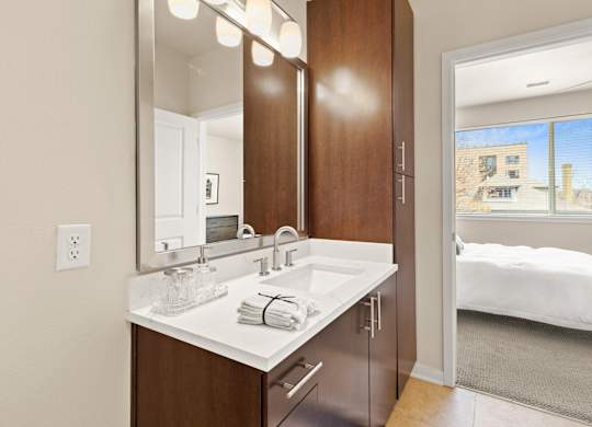 Modern sytle bathroom vanity with marble-look countertops with a view into the bedroom at Sylvan Uptown, Colorado, 80203