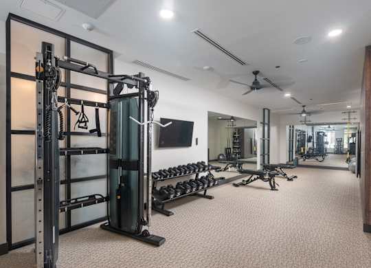 State-of-the-art fitness club with mirrored walls, free weights, ceiling fans, and a tv at Sylvan Uptown, Denver, CO, 80203
