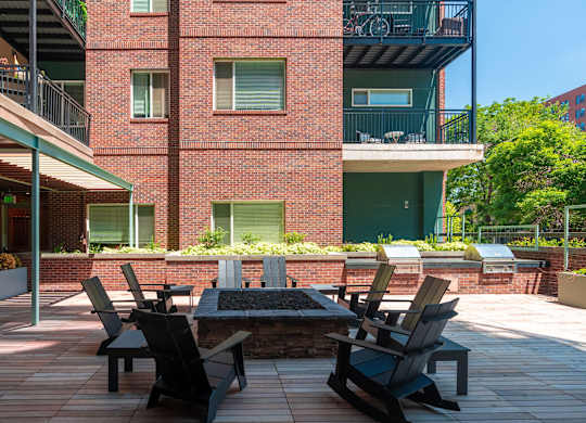 Red brick outdoor patio with chairs surrounding a fire pit at Sylvan Uptown, Colorado, 80203