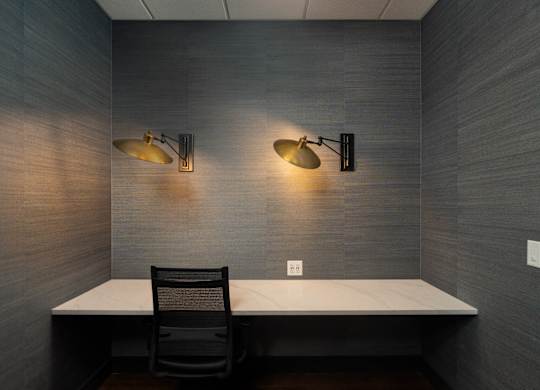Private resident workspace with built-in desk, two gold wall sconces, and outlets at Sylvan Uptown, Denver, CO, 80203