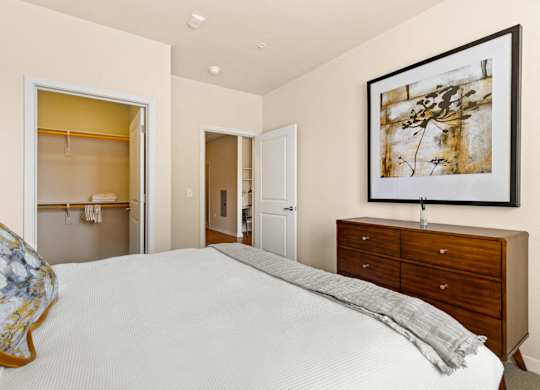 a bedroom with a bed, dresser, and an open closet at Sylvan Uptown,Colorado, Denver