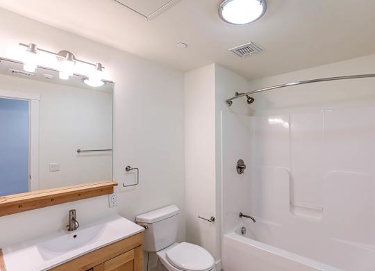 A white bathroom with a toilet, sink, and bathtub at Park87 Apartments, Cambridge