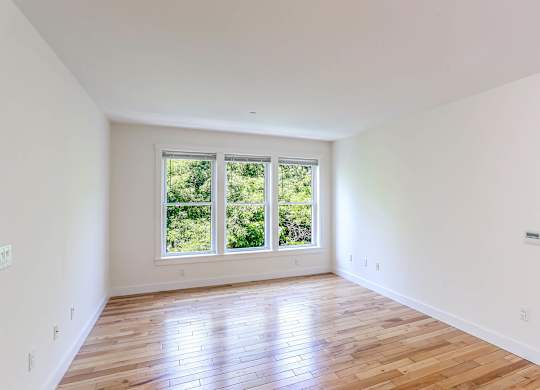 A room with wooden floors and a large window at Park87 Apartments, Cambridge 02138