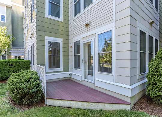 A house with a green and beige exterior and a red deck at Park87 Apartments, Cambridge 02138