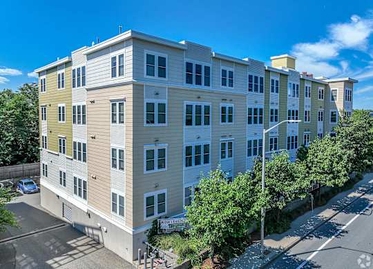 A multi-story apartment building with a parking lot in front at Park87 Apartments, Cambridge 02138