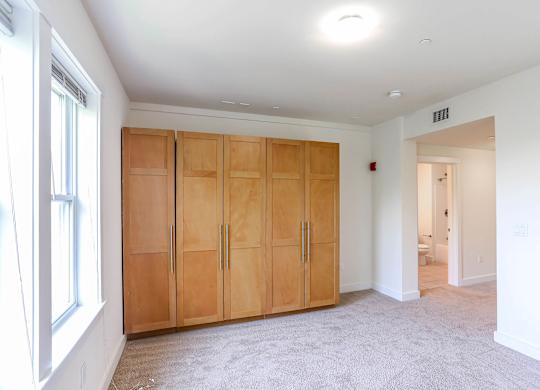 A room with a set of wooden doors and a carpeted floor at Park87 Apartments, Massachusetts