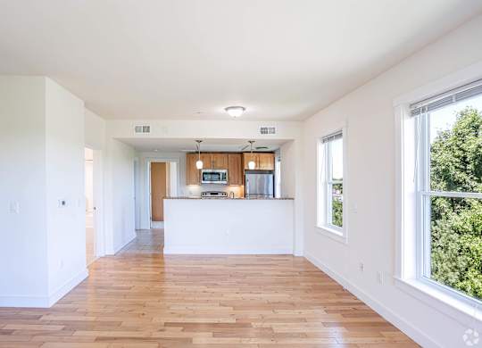 A spacious room with wooden floors and white walls at Park87 Apartments, Cambridge