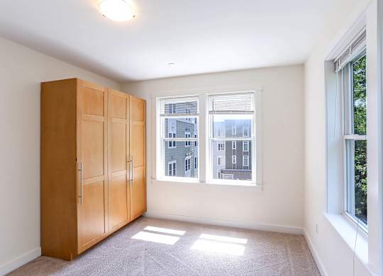 A room with a large window and a wooden cabinet. at Park87 Apartments, Cambridge, MA, 02138