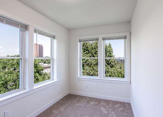 A room with two windows overlooking a cityscape and greenery at Park87 Apartments, Cambridge, Massachusetts