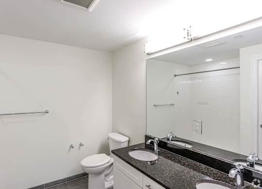 A white bathroom with a toilet, sink, and shower at 7 Cameron Apartments, Massachusetts