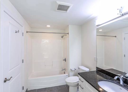 An updated bathroom with a black counter top and shower at 7 Cameron Apartments, Cambridge, MA, 02140
