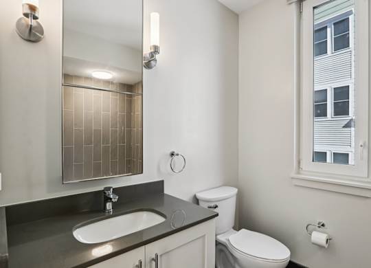 Bathroom with a sink and mirror at Park77 Apartments, Cambridge