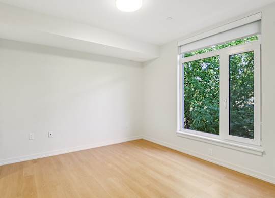 Bedroom with oversized windows and wooden floor at Park77 Apartments, Massachusetts