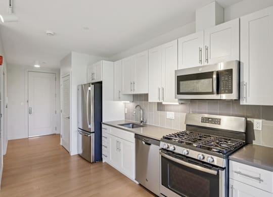 Kitchen with stove top oven and refrigerator at Park77 Apartments, Cambridge