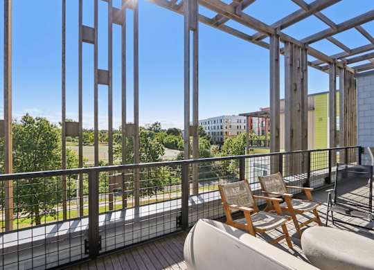 Balcony with a table and chairs overlooking a green area at Park77 Apartments, Cambridge, 02138