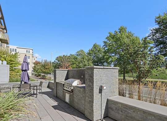 Patio area with a table and chairs and a stone wall at Park77 Apartments, Cambridge, MA
