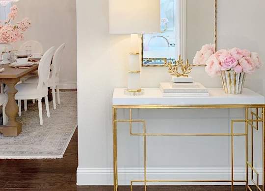 a white desk with a mirror and a table with a chair