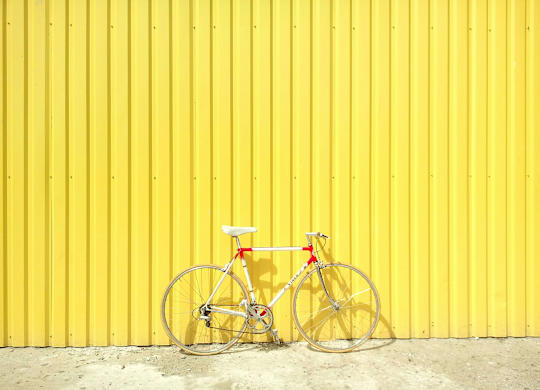 a bike parked in front of a yellow wall