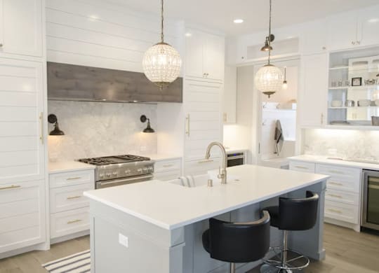 A modern kitchen with a large island and bar stools.