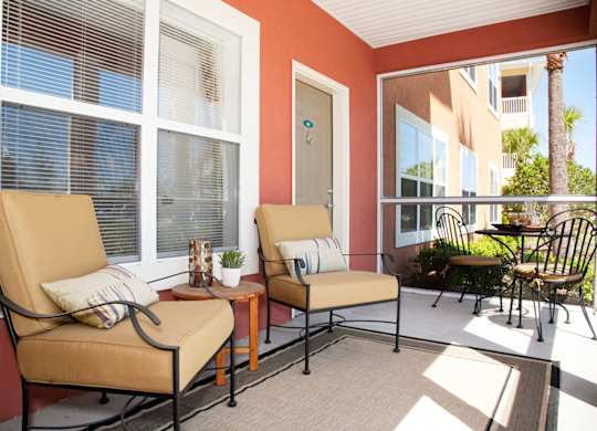 Two chairs and a table are on a patio.