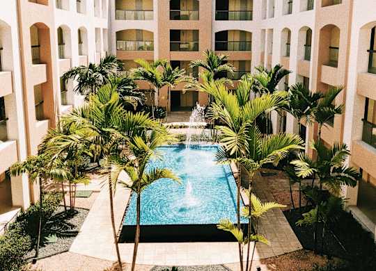 a swimming pool in the middle of a building with palm trees
