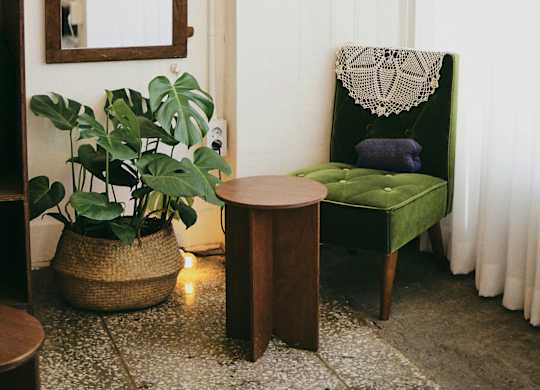 a living room with a green chair and a mirror