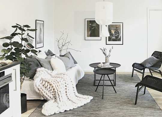 a black and white living room with a white sofa and black chairs