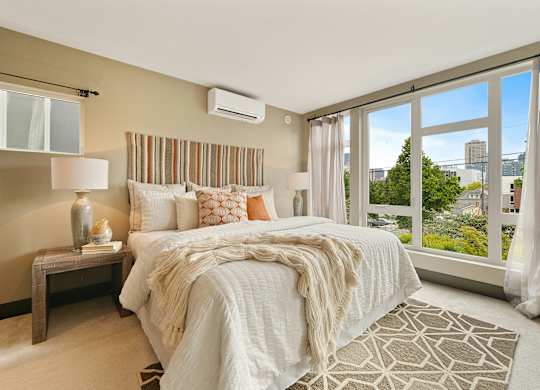 A bedroom with a large bed and a view of the city.