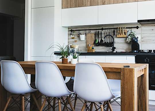 a kitchen with white cabinets and a wooden table and chairs