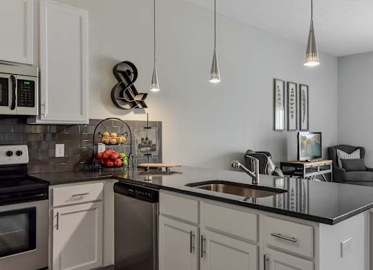 an open kitchen and living room with a large counter top