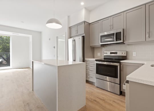 Modern kitchen with stainless steel appliances and white cabinetry.