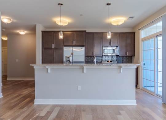 A kitchen with a white counter and brown cabinets.