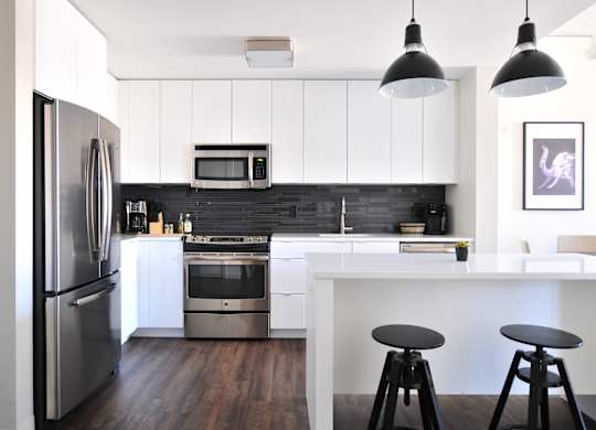 a kitchen with white cabinets and stainless steel appliances