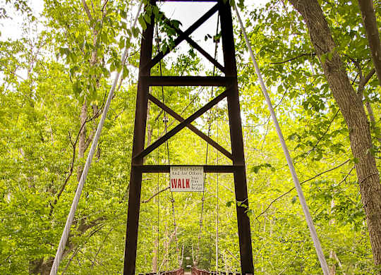 A wooden walkway leads to a sign that says