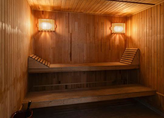 A wooden sauna with benches and lights.