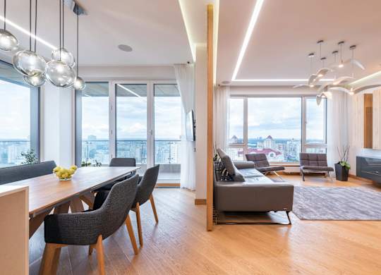 A modern living room with a dining table and chairs.