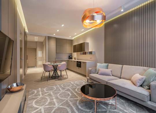 A modern living room with a grey couch and a round table.