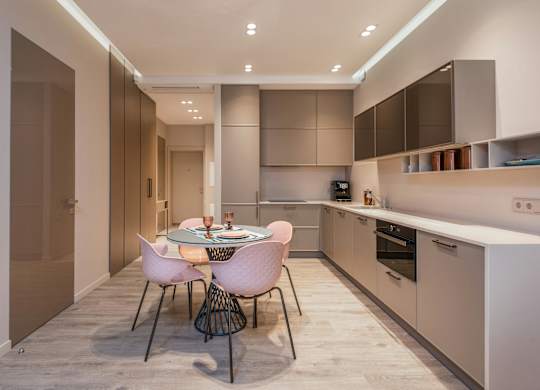 A modern kitchen with a dining table set for two.