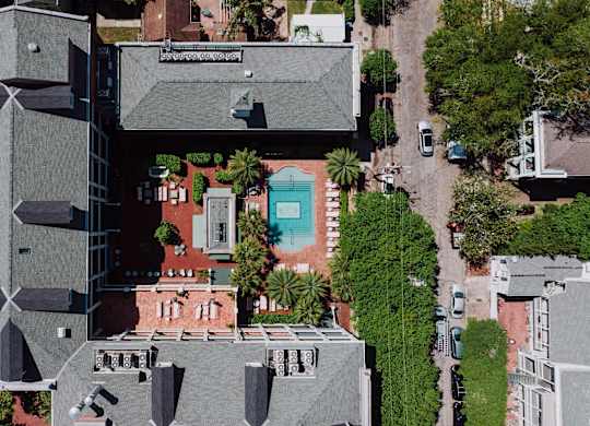 A modern building with a grey roof and a pool in the middle.