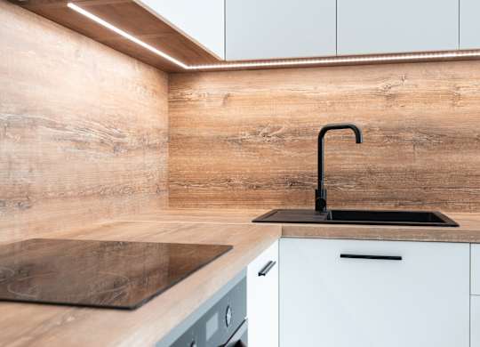 a kitchen with white cabinets and a black sink with a black faucet