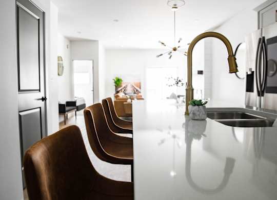A modern kitchen with a long table and chairs.