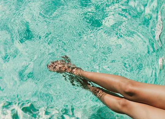 A person's legs are submerged in water.