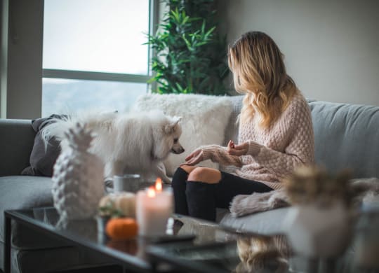 a woman sitting on a couch with her dog