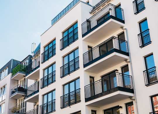 A white apartment building with black railings and balconies.