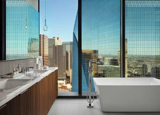 A modern bathroom with a large window overlooking a cityscape.
