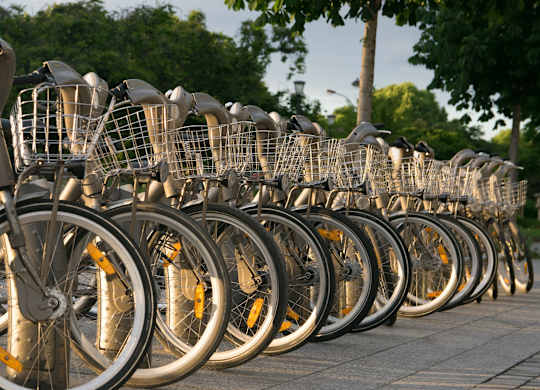 A row of bicycles are parked in a row.