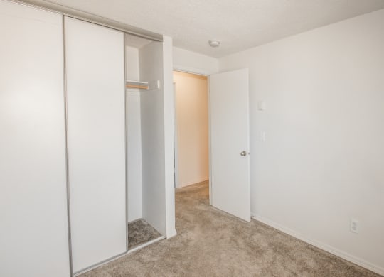 Todd village  vacant apartment bedroom with a white closet door and a carpeted floor