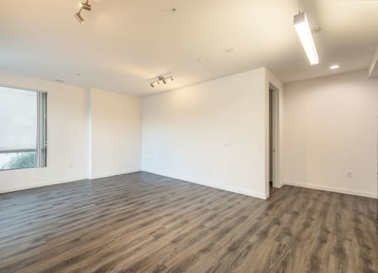an empty living room with white walls and a window